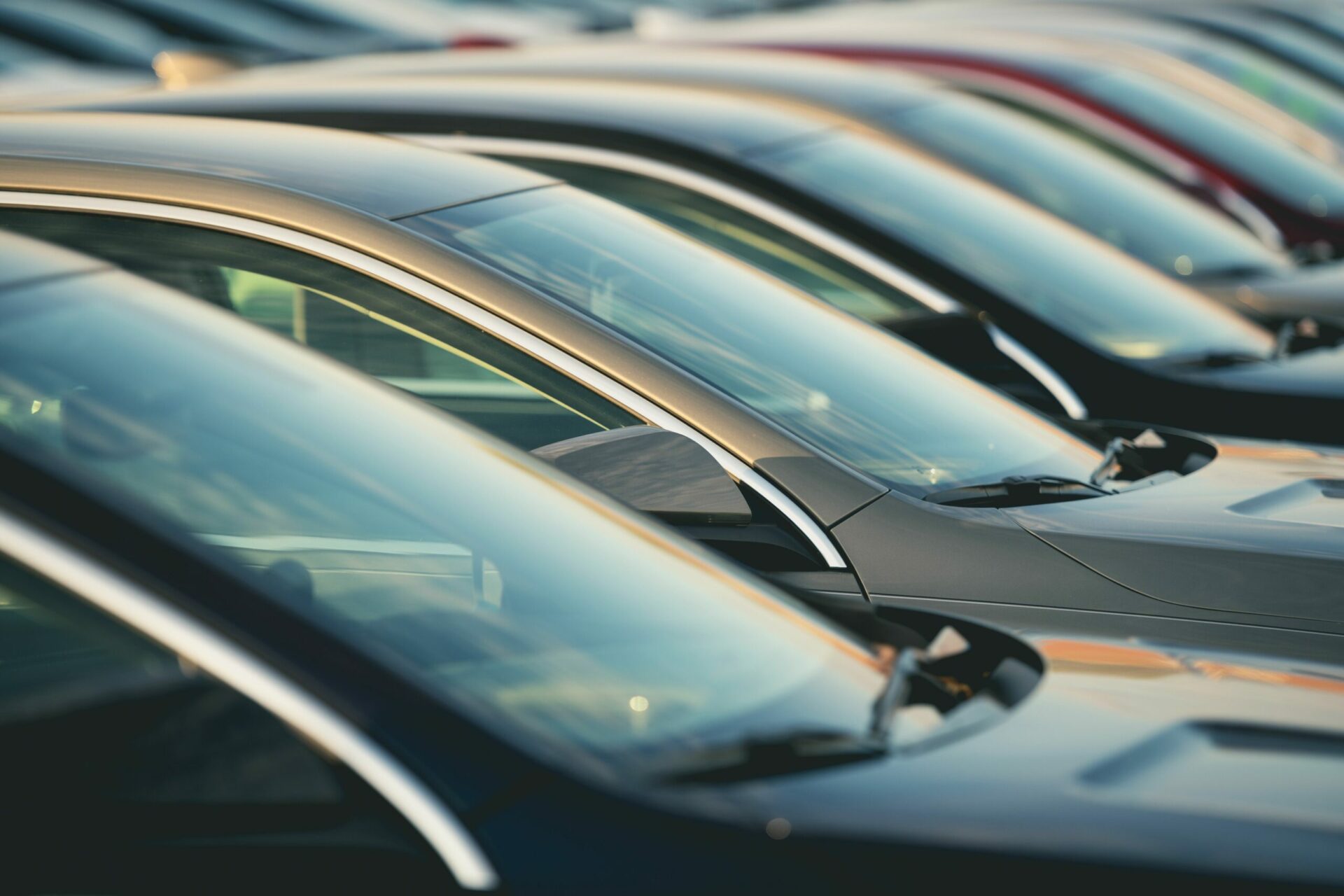 Four black cars in a row at a car dealership